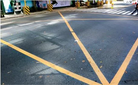 pavement markings forming a yellow box at intersections where vehicles must not stop to prevent traffic obstruction.