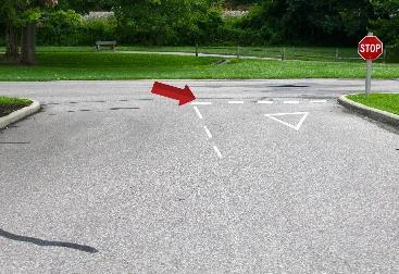 pavement markings instructing drivers to give way to all traffic at a designated intersection.