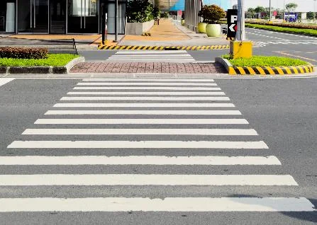 road pavement markings indicating pedestrian crossings at intersections.
