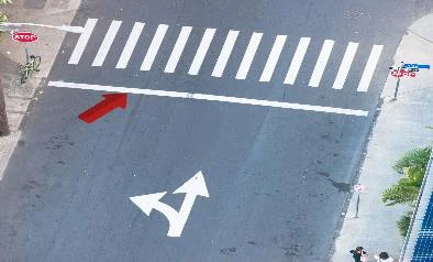 a pavement marking instructing vehicles to stop before the white line.